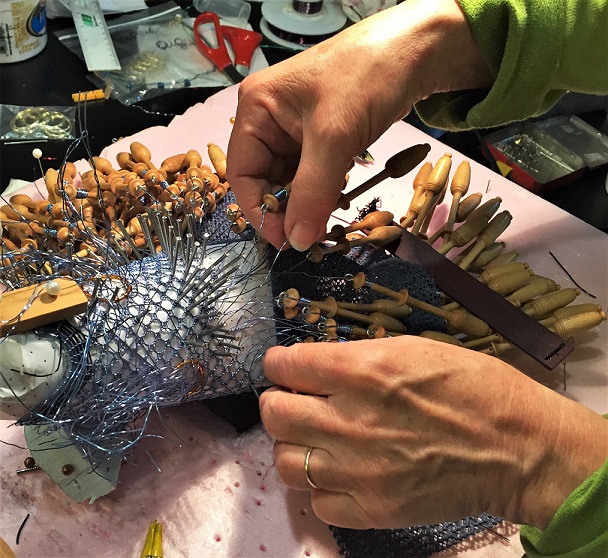 Mains habiles de Véronique Louppe à l'œuvre lors de la création d'une sculpture en dentelle aux fuseaux