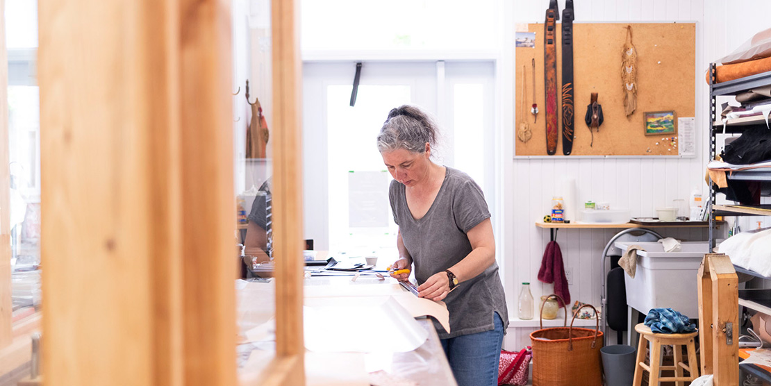 Artiste travaillant le cuir dans un des ateliers du Vivoir